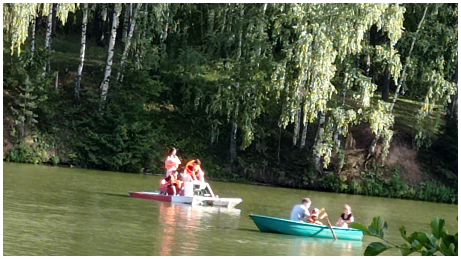 Посетители парка катаются на лодках по реке "Харинка" в акватории.